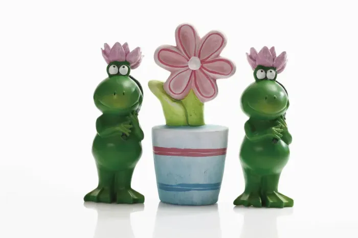 Framed Print : Two frog figures with artificial flower pot