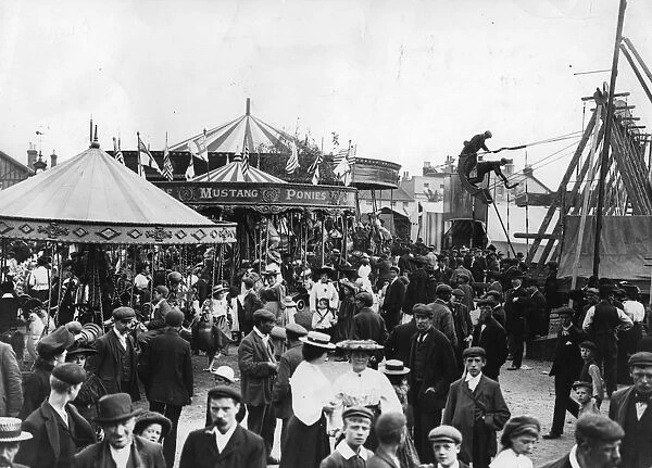 Fun Fair. December 1912: View of a fair, showing carousel and swing-boat rides, 1912