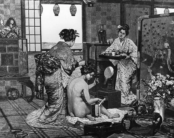 Geisha. circa 1900: A woman plays an instrument whilst having her hair