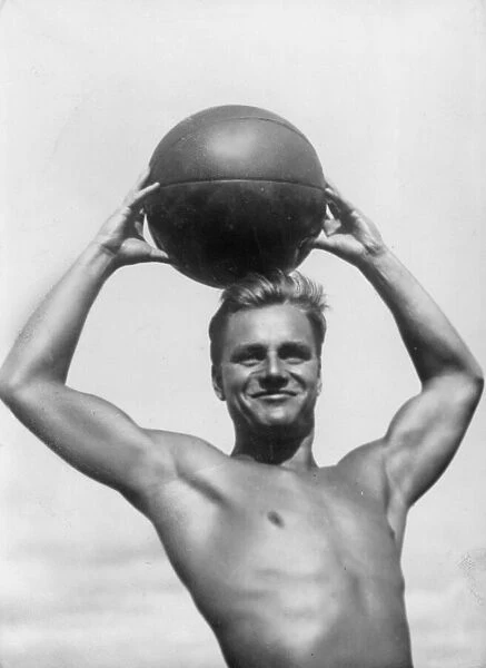 Atlas. circa 1930: A German athlete poses with a beach ball