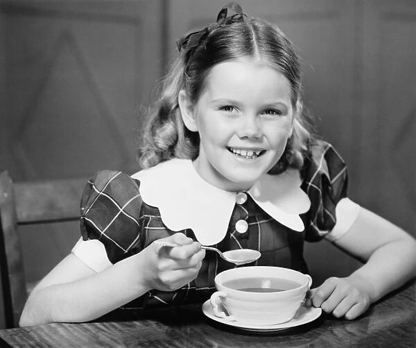 Girl (10-11) eating soup at table (B&W), portrait