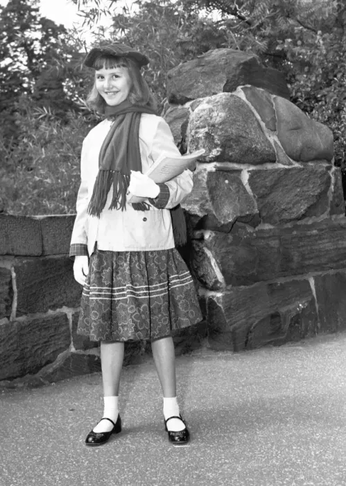 Framed Print : Girl (12-13) holding book, posing by wall, (B&W), portrait