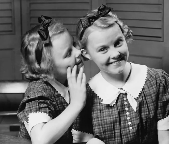 Framed Print : Girl (12-13) indoors whispering into ear of twin sister, (B&W) Framed Print : Girl (12-13) indoors whispering into ear of twin sister, (B&W)