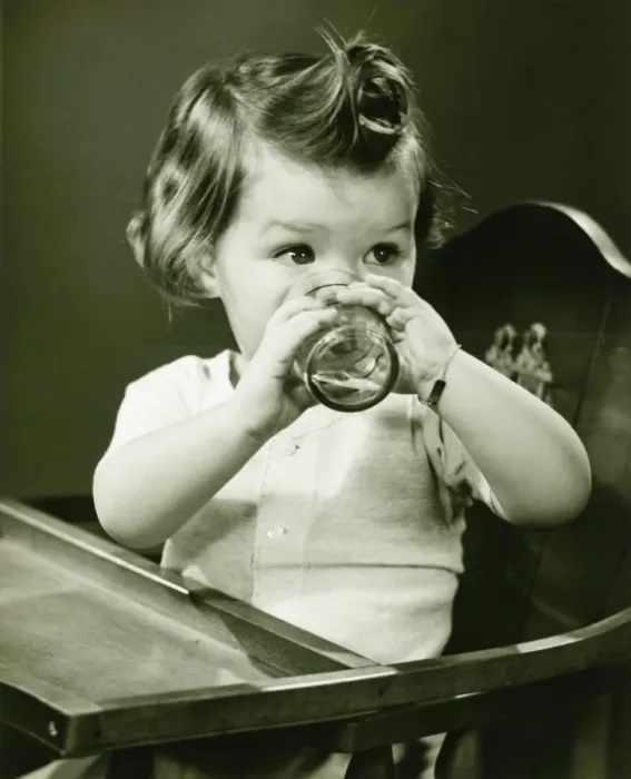 Framed Print : Girl (2-3) sitting in high chair, drinking water from glass, (B&W) Framed Print : Girl (2-3) sitting in high chair, drinking water from glass, (B&W)