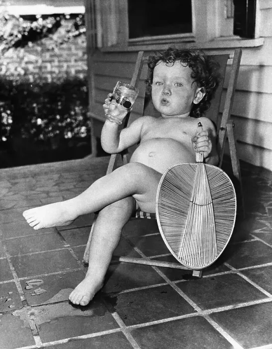Framed Print : Girl (2-3 years ) sitting on lounge chair with drink and fan Framed Print : Girl (2-3 years ) sitting on lounge chair with drink and fan