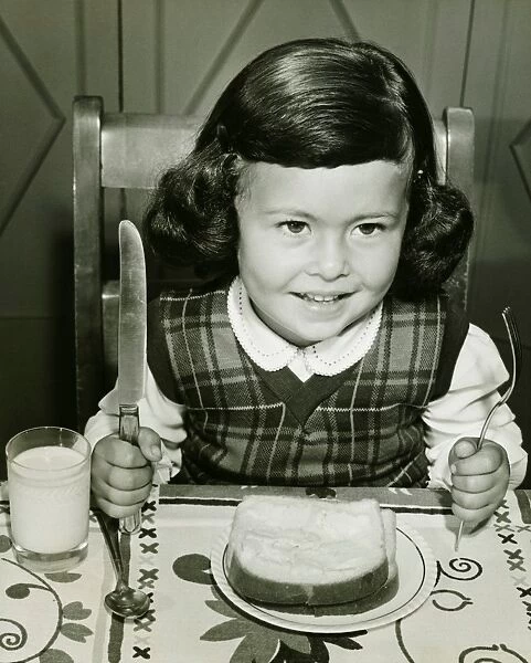 Girl (4-5) having meal, holding fork and knife, (B&W)