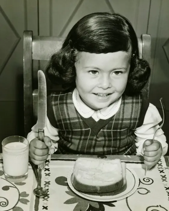 Framed Print : Girl (4-5) having meal, holding fork and knife, (B&W) Framed Print : Girl (4-5) having meal, holding fork and knife, (B&W)