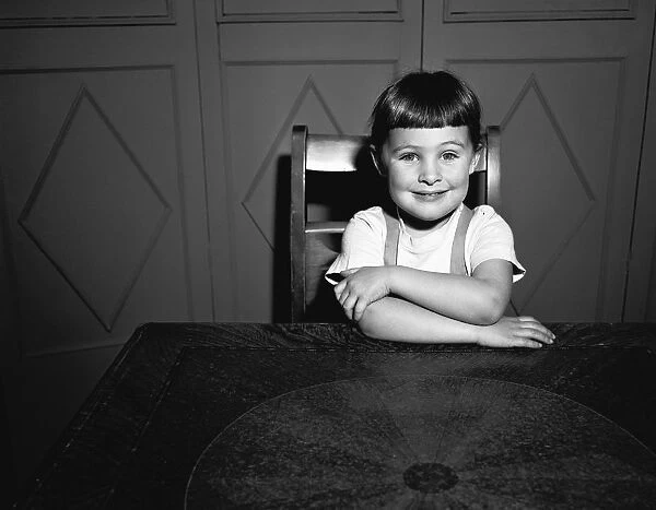 Girl (5-5) sitting at table, (B&W), portrait