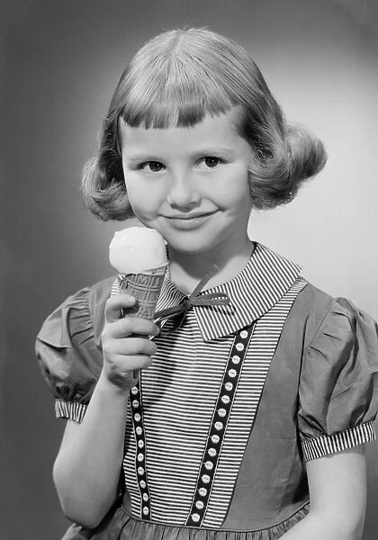 Girl (6-7) eating ice cream, portrait