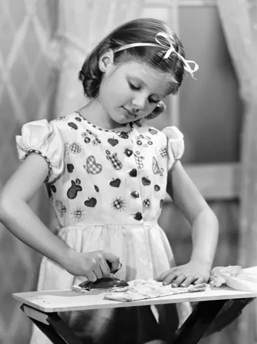 Framed Print : Girl (7-9) using toy iron (B&W) Framed Print : Girl (7-9) using toy iron (B&W)