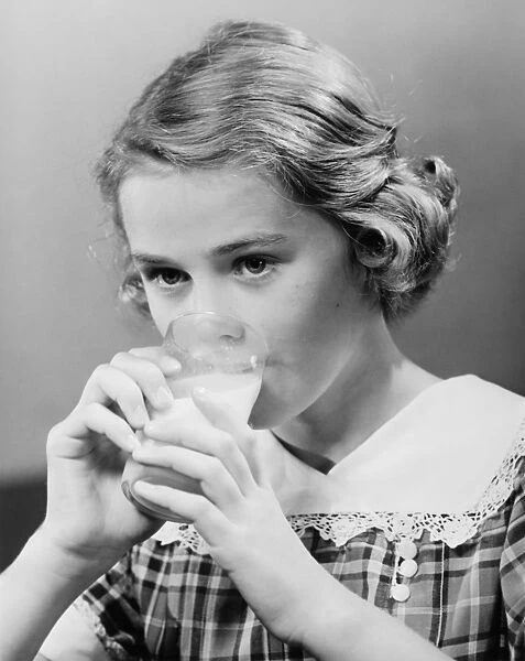 Girl (8-9) drinking milk from glass (B&W)