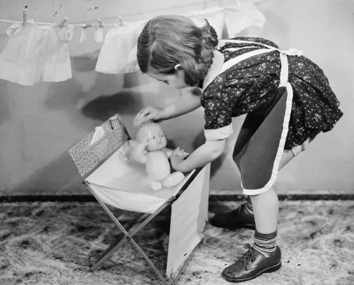 Framed Print : Girl (8-9) playing with doll, (B&W) Framed Print : Girl (8-9) playing with doll, (B&W)