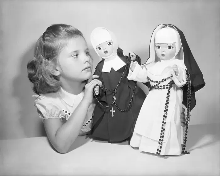 Framed Print : Girl Playing with Nun Dolls