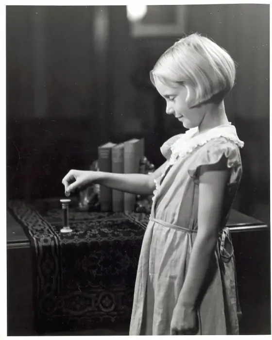 Framed Print : Girl Putting Money Into Dime Bank Framed Print : Girl Putting Money Into Dime Bank