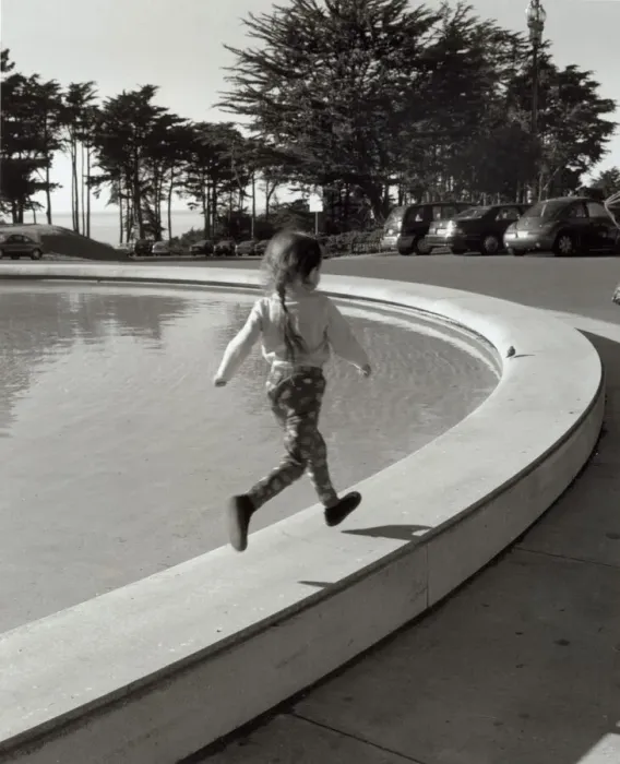 Framed Print : Girl running along edge of fountain Framed Print : Girl running along edge of fountain