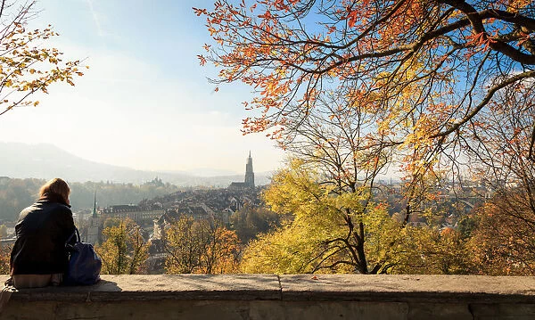 A girl sitting to enjoy scenery of the Old City of Bern at rose garden