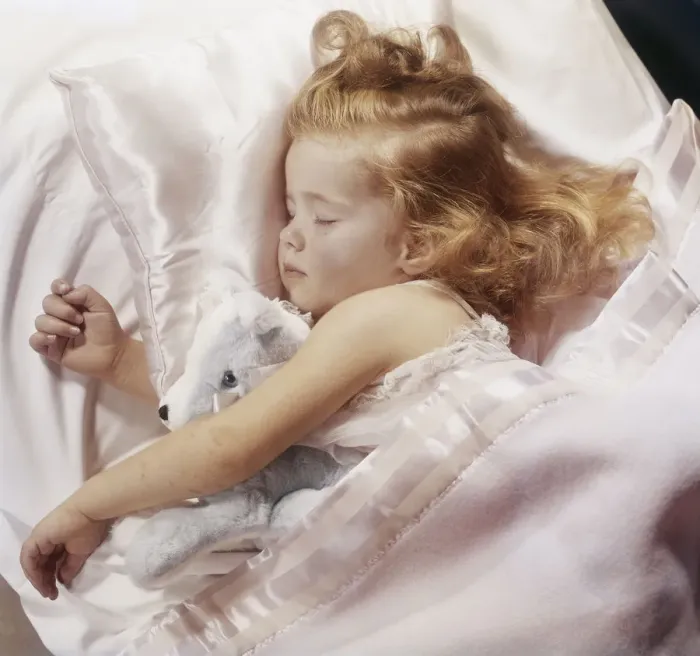 Framed Print : Girl with soft toy sleeping on bed Framed Print : Girl with soft toy sleeping on bed