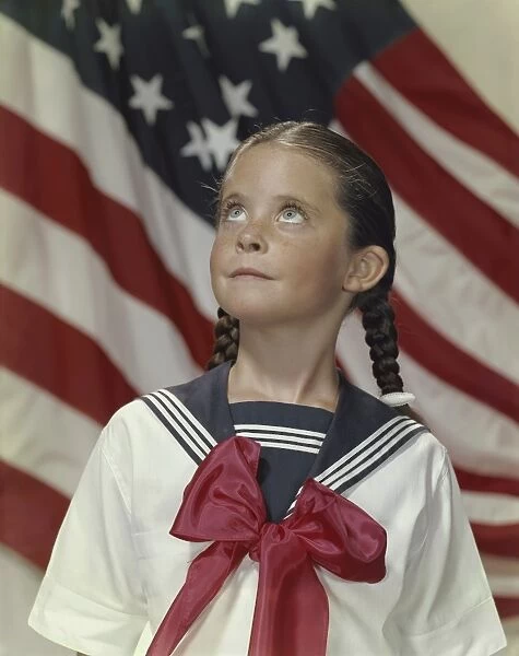 Girl standing and looking up with stars and stripes in background