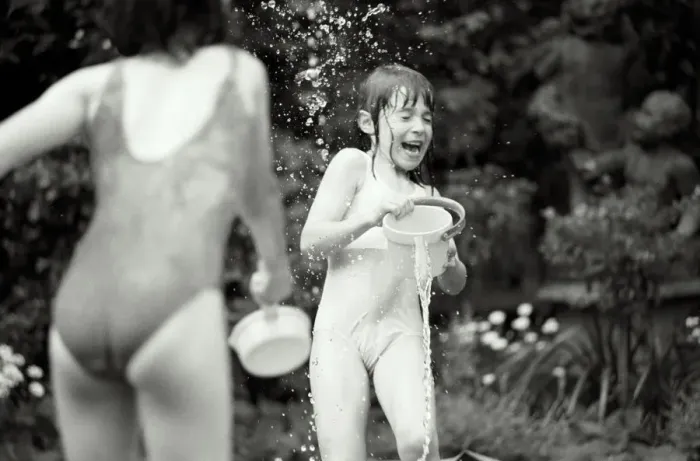 Framed Print : Two girls (7-9) in swimwear having water fight in garden (B&W) Framed Print : Two girls (7-9) in swimwear having water fight in garden (B&W)