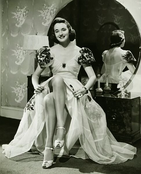 Glamorous woman in evening gown showing legs, portrait, (B&W)