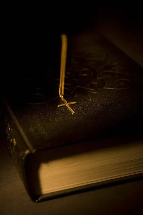 Framed Print : Gold cross pendant resting on a book Framed Print : Gold cross pendant resting on a book