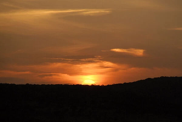 Golden sunset falling behind silhouetted hills in the Phinda Private Game Reserve, KwaZulu-Natal, South Africa