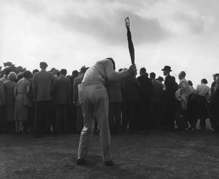 Framed Print : Golf Club. A crowd watching golf, whilst a man in the foreground practises Framed Print : Golf Club. A crowd watching golf, whilst a man in the foreground practises