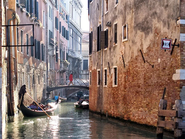 Gondola with tourists on a canal in Venice