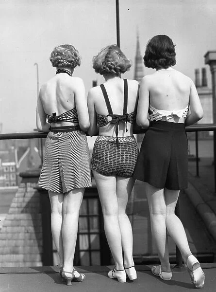 Good View. 1st April 1935: Three models wearing two-piece swimsuits with tailored shorts