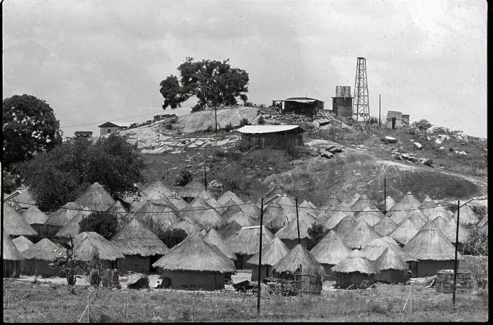 Framed Print : Grass Huts at Base of Hill