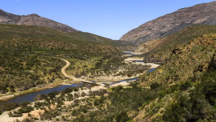 Framed Print : A gravel road in a mountainous area crossing over a river on a low level bridge near Framed Print : A gravel road in a mountainous area crossing over a river on a low level bridge near