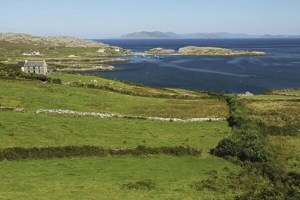 green fields and a little farmhouse on the coastline of the beara peninsula in munster province