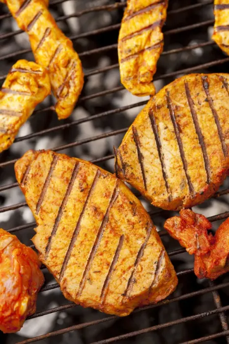 Framed Print : Grilled meat, marinated turkey breast and beef steaks on a grill, hot coals underneath