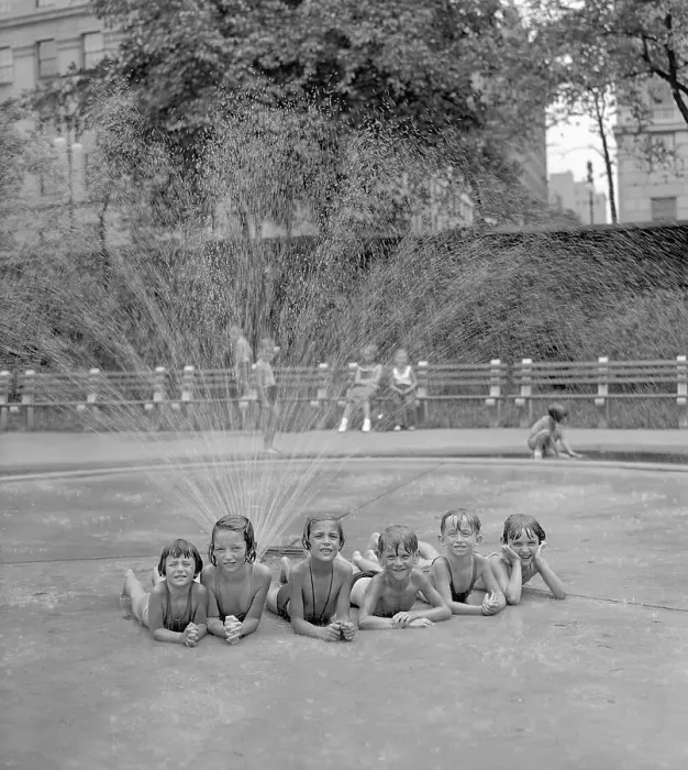 Framed Print : Group of girls (6-7) and (8-9) boys taking refuge from heat under sprinkler Framed Print : Group of girls (6-7) and (8-9) boys taking refuge from heat under sprinkler