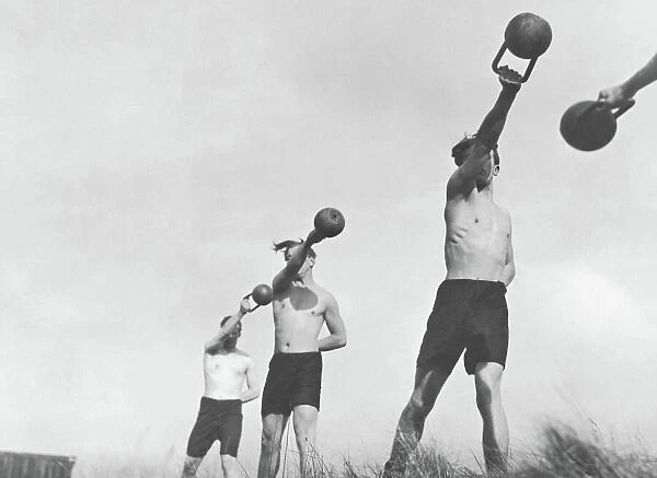 Group of young men exercising outdoors with weights (B&W)