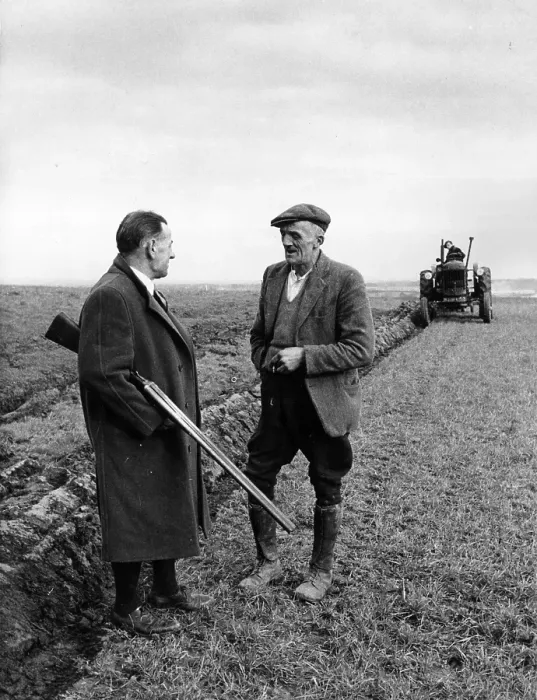 Framed Print : Gun Law. January 1953: A farmer with a double barrelled shotgun talks to Framed Print : Gun Law. January 1953: A farmer with a double barrelled shotgun talks to