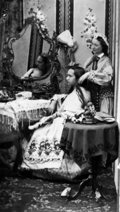 Framed Print : Hair Help. circa 1865: A seated lady having her hair attended to by a servant Framed Print : Hair Help. circa 1865: A seated lady having her hair attended to by a servant