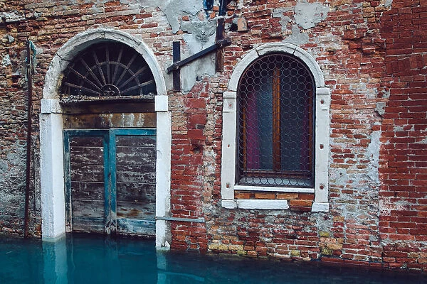 Half sunken door of townouse by the canal in Venice, Italy