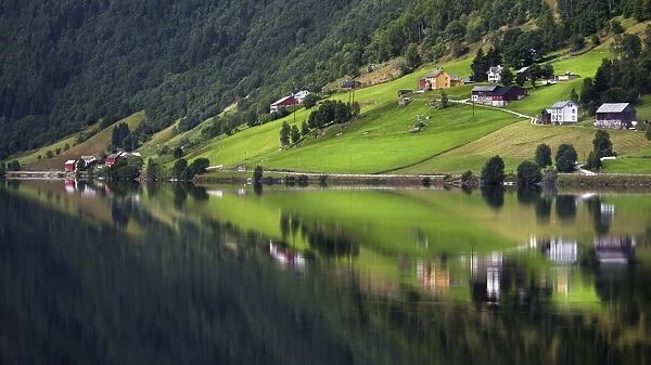 Hamlet of Heggland reflected in Lake Oppheimsvatnet, Oppheim, Hordaland, Norway