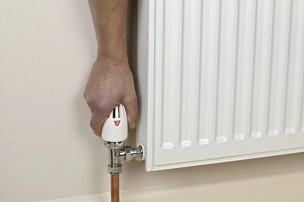 Hand on handwheel valve of radiator