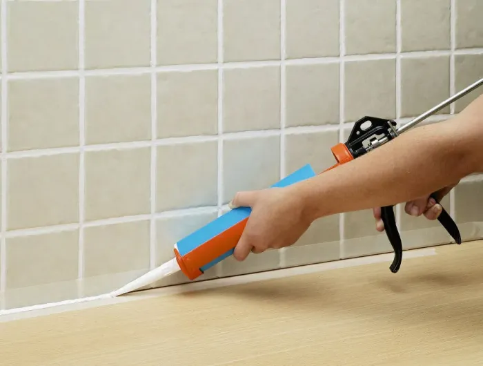 Framed Print : Hands applying sealant to tiles with sealant tube Framed Print : Hands applying sealant to tiles with sealant tube
