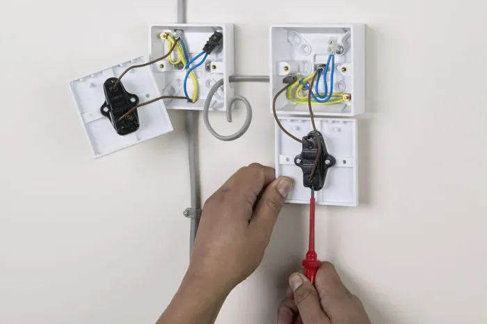 Framed Print : Hands holding screw driver to light switch, face plate off Framed Print : Hands holding screw driver to light switch, face plate off