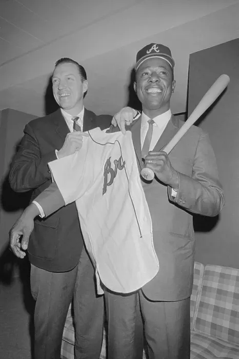 Framed Print : Hank Aaron Being Assisted with Uniform Shirt and Baseball Bat Framed Print : Hank Aaron Being Assisted with Uniform Shirt and Baseball Bat