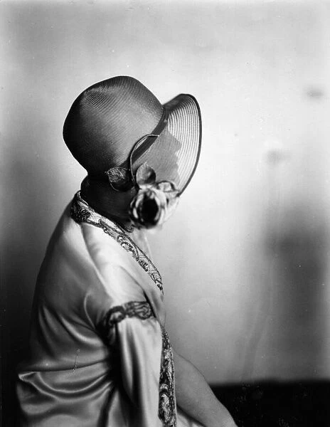 Hat Brim. circa 1928: A woman is silhouetted by her hat brim