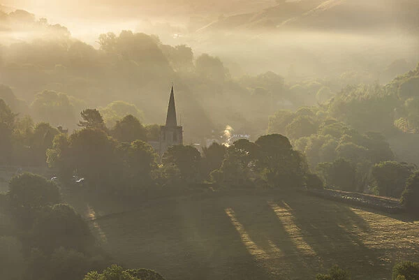 Hathersage church surrounded by the hills of the Peak District at sunrise. UK