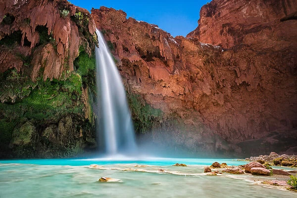 Havasu Falls in Arizona falling into blue green waters below