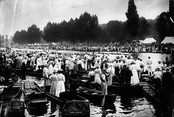 Henley. circa 1910: Crowds in punts on the Thames watching the Henley Regatta