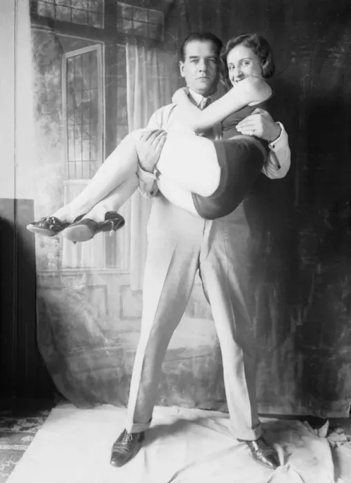 Framed Print : My Hero. circa 1930: The stern hero in collar and tie carries off the swimsuited heroine