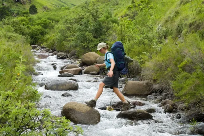 Framed Print : Hiker Boulder Hopping Across a River