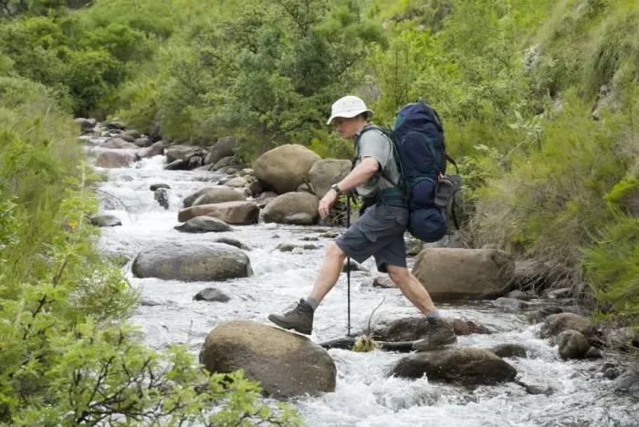 Framed Print : Hiker Boulder Hopping Across a River Framed Print : Hiker Boulder Hopping Across a River